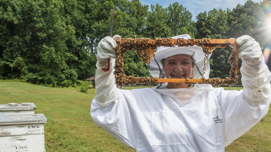 Dr. Kaira Wagoner with a hive of bees